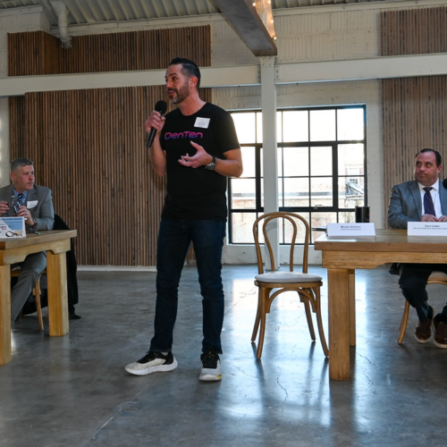 Michael Esposito speaking in front of a panel of 4 professionals